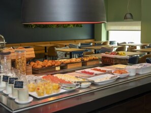 A buffet with various food items and a seating area with tables and chairs. - Travelodge Malaga Aeropuerto (Málaga)