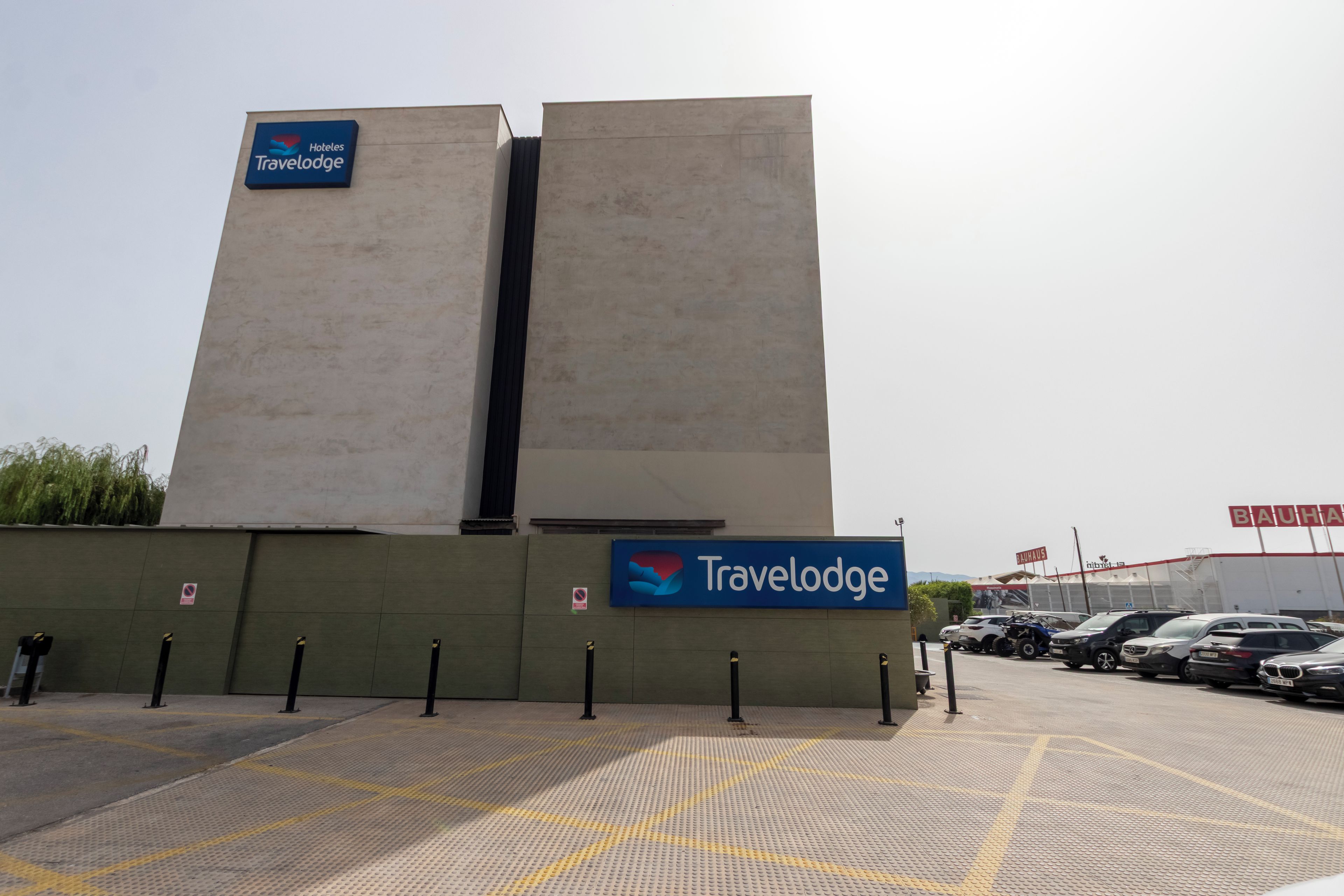 Ein Travelodge Hotel mit modernem Design, mit einer gut sichtbaren Beschilderung und einem Parkplatz mit taktiler Bodenindikation für sehbehinderte Menschen.