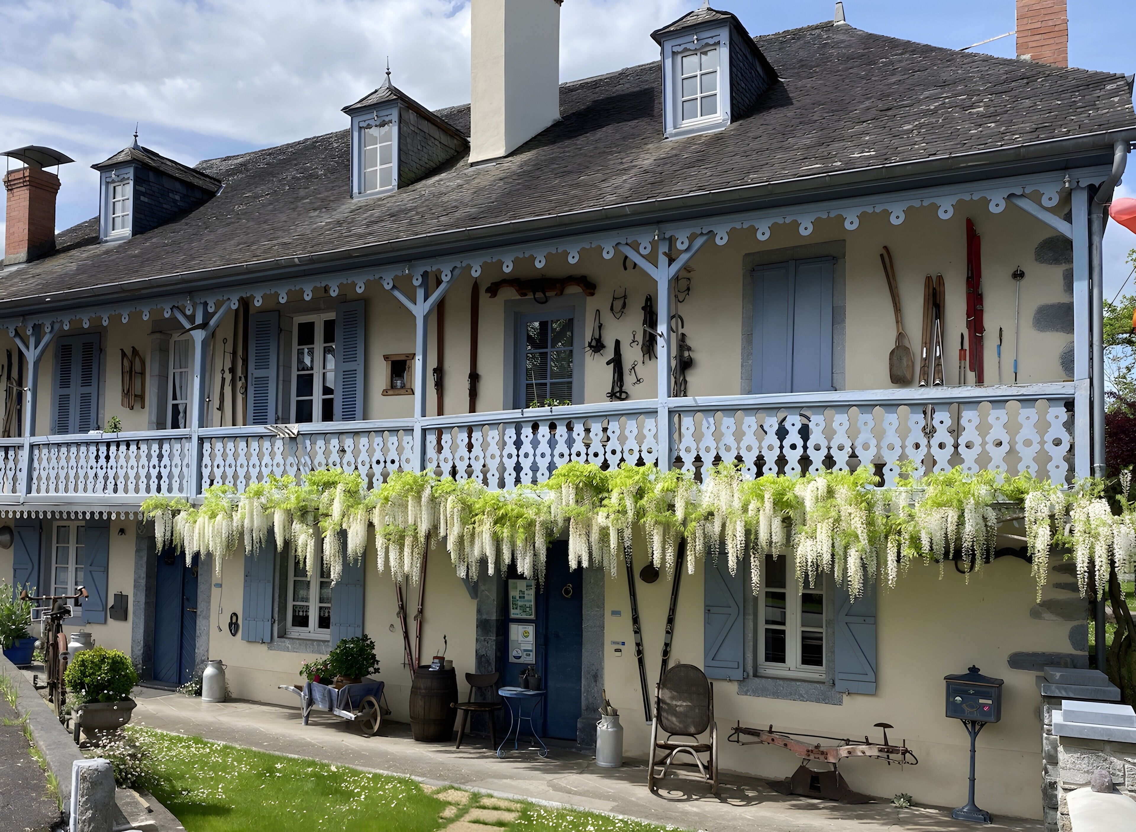 A traditional building with a balcony, outdoor seating, and a variety of outdoor equipment.