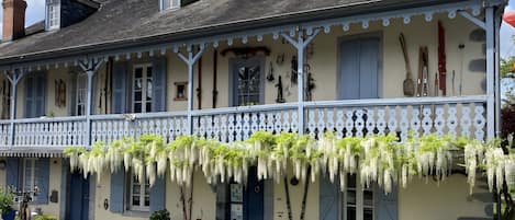 A traditional building with a balcony, outdoor seating, and a variety of outdoor equipment.