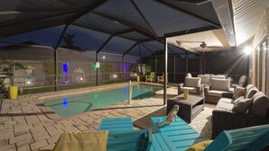An outdoor pool area with lounge chairs and a covered patio.
