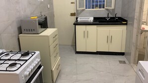 A compact kitchen with a gas stove, a microwave, and a sink.