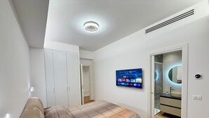 A bedroom with a bed, wardrobe, TV, and bathroom. - House Gordiani Comfort Stay (Roma)