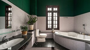 A bathroom with a bathtub, toilet, sink, and a window with bars. - Villa Paradise 6Bedroom (Thu Duc)