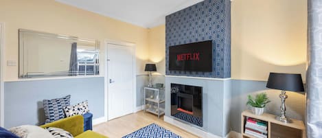 Een smart-tv, een open haard en boeken