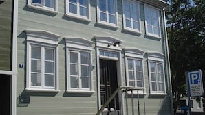 Ein zweistöckiges Gebäude mit Eingangstür, Treppe und Parkschild.