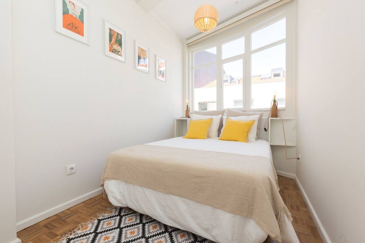 Une chambre à coucher avec un lit, une fenêtre et une étagère fixée au mur.