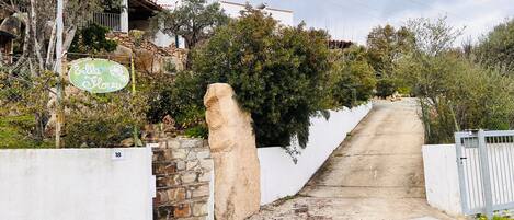 Una escalera de piedra conduce a un edificio de paredes blancas con un letrero que dice "Bella Flores".