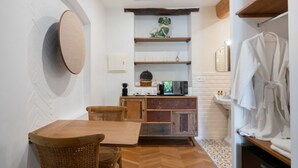 Eine kleine Küche mit Holztisch und -stühlen, einem Einbauschrank und einer Mikrowelle.