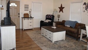 A living room with a white cabinet, a black coffee table, a brown sofa, and a star decoration on the wall.