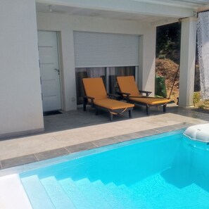 A pool area with two lounge chairs and a door. - A COMFORTABLE HOME (Allègre-les-Fumades)