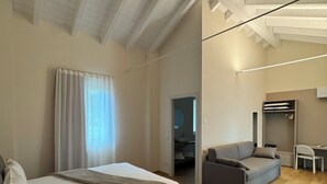 Une chambre moderne avec un grand lit, un canapé et un espace bureau.