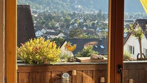 A wooden deck with a view of a town and mountains. - FEWOBuergstadt.de Light-flooded, cozy, spaciousFeWo with distant view (Bürgstadt)