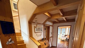 A wooden staircase leading to a loft bedroom with a sloped ceiling, a small desk, and a window overlooking the room. - FEWOBuergstadt.de Light-flooded, cozy, spaciousFeWo with distant view (Bürgstadt)