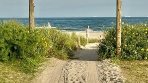 A sandy path leading to a beach with wooden posts on either side. - The Breeze Beachfront Resort (Surfside Beach)