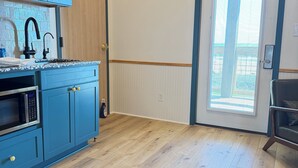 A kitchen with blue cabinets, a microwave, and a sink. - The Breeze Beachfront Resort (Surfside Beach)