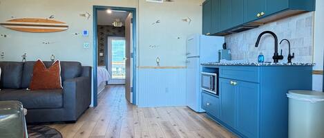 Una cocina moderna con armarios azules, un grifo negro y un horno empotrado.