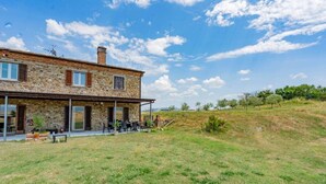 Una casa de piedra con un patio y zona de estar al aire libre.