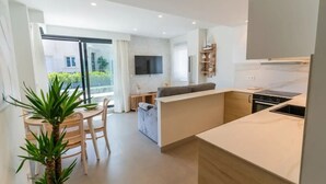Un appartement moderne comprenant une cuisine, un coin repas et un espace de vie.