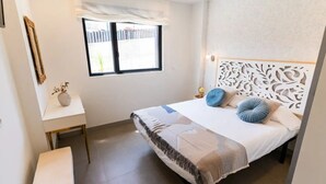 Une chambre à coucher comprenant un lit, une table de chevet, une fenêtre et une tête de lit décorative.