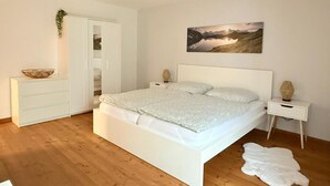 A bedroom with a white bed, a nightstand, a white dresser, and a painting on the wall. - NEW! Time out at the Hirzenkopf (Steinberg-Deckenhardt)