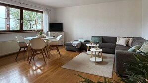 A modern living room with a dining area, a grey sofa, and a TV. - NEW! Time out at the Hirzenkopf (Steinberg-Deckenhardt)