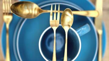 Un plato azul con cuchara y tenedor.