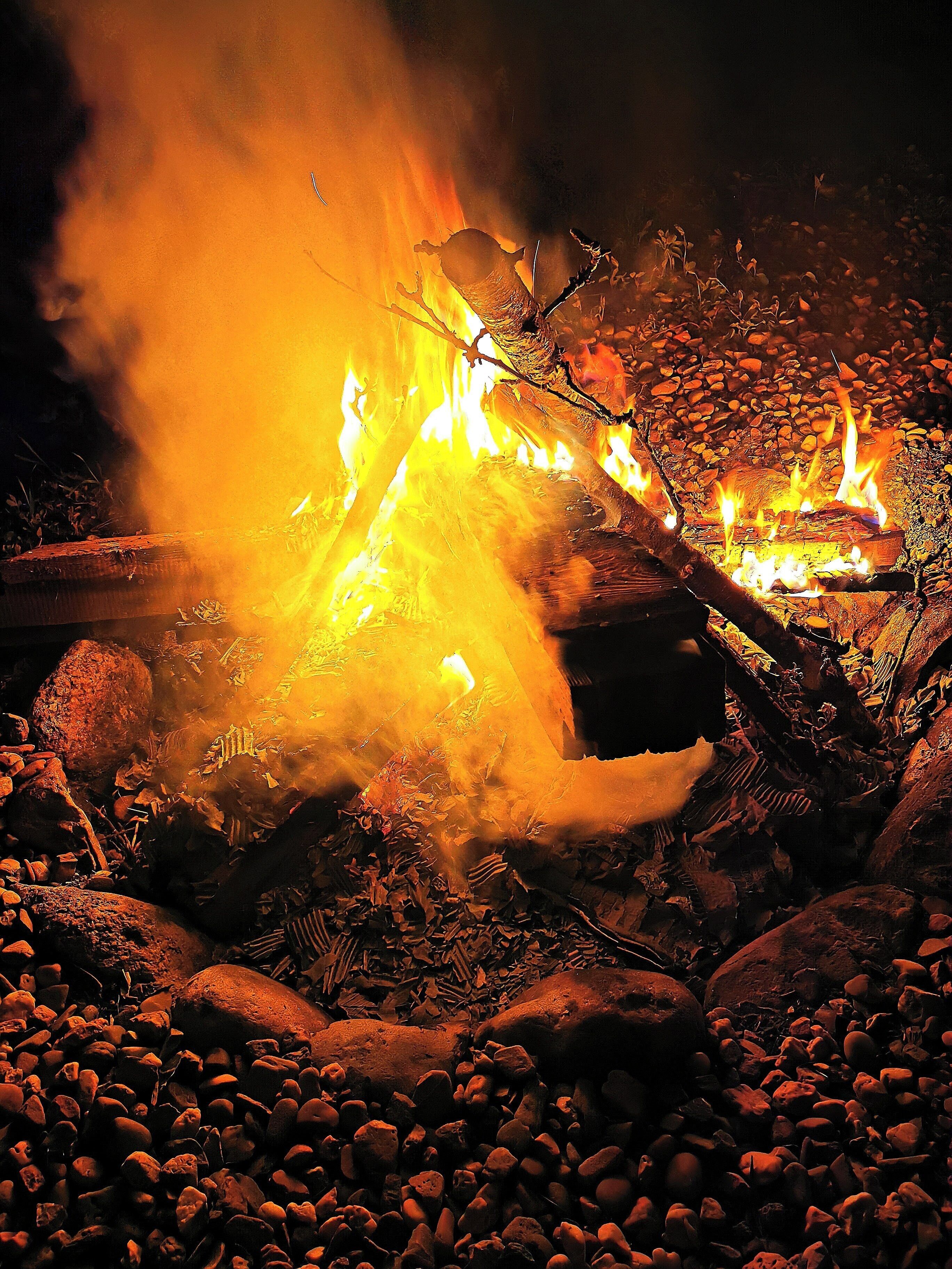 A campfire with logs and rocks around it.