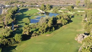 A golf course with a pond, surrounded by trees and a highway in the background. - Family friendly home by Disneyland Universal DTLA SGV Pasadena Arcadia (San Gabriel)