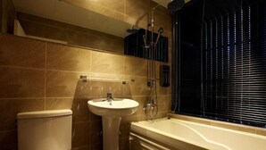 Ein Badezimmer mit Toilette, Waschbecken, Badewanne und Dusche.