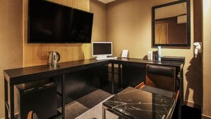 A hotel room with a large flat-screen TV mounted on the wall, a small desk with a computer, a coffee maker, and a mirror. - Hotel Blanc in Gangnam (Yeoksam) (Seoul)