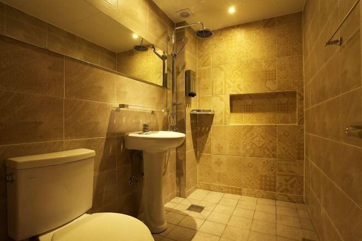 A bathroom with a toilet, sink, and shower.