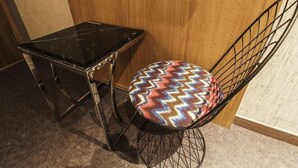 A black marble table and a wireframe chair with a colorful zigzag cushion. - Hotel Blanc in Gangnam (Yeoksam) (Seoul)