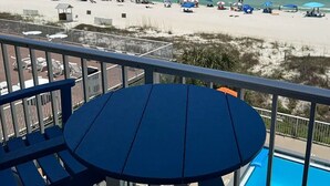 Varanda com vista para uma praia e uma piscina.
