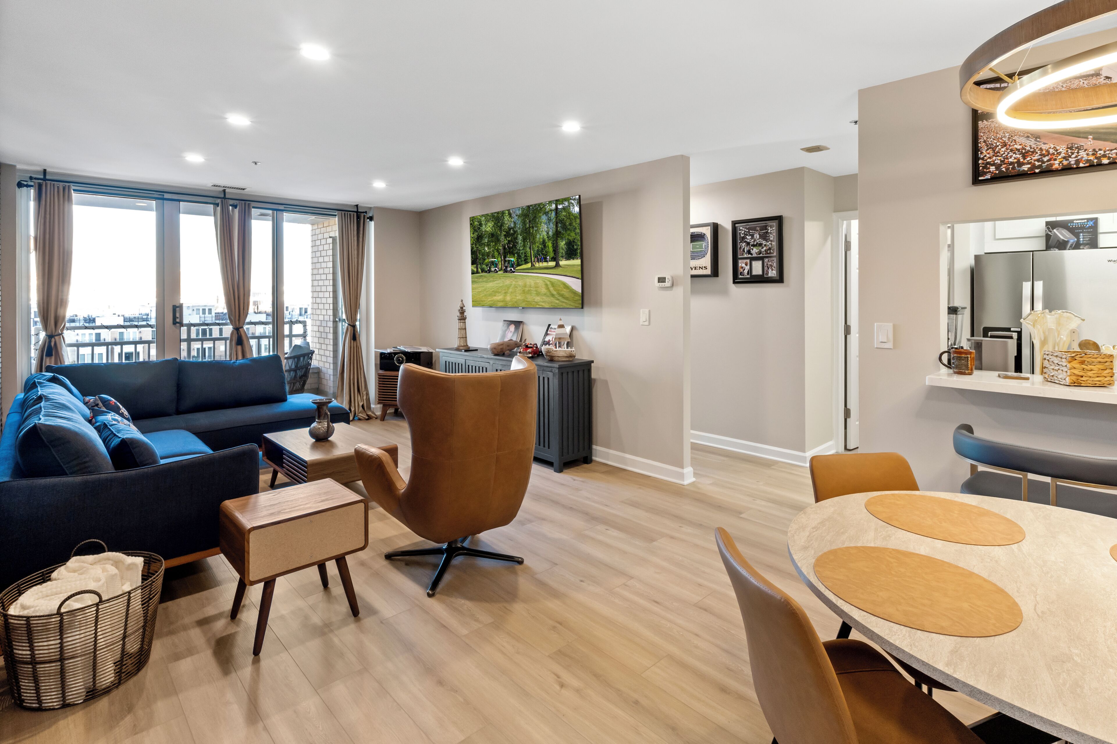 Ein modernes Wohnzimmer mit Sofa, Sessel und Esstisch.