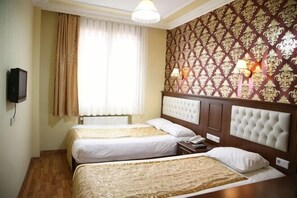 A hotel room with two beds, a television, a window with curtains, and patterned wallpaper. - Hotel Agan Oldcity Istanbul (Istanbul)