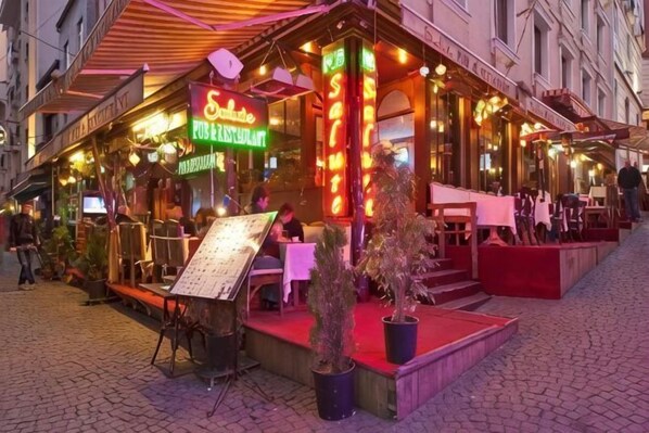 A restaurant with outdoor seating, a neon sign, and a menu stand. - Hotel Agan Oldcity Istanbul (Istanbul)