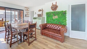 Una sala de estar moderna con una mesa de comedor, sofá de cuero y una pared verde con la palabra 'HOME' escrita.