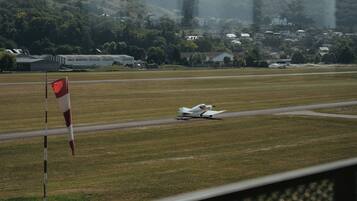 A small aircraft on a runway with a flag in the foreground.