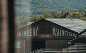 Un edificio de madera con la inscripción 'CHAMBERY AVIATION' y '1913-2013' en la fachada.