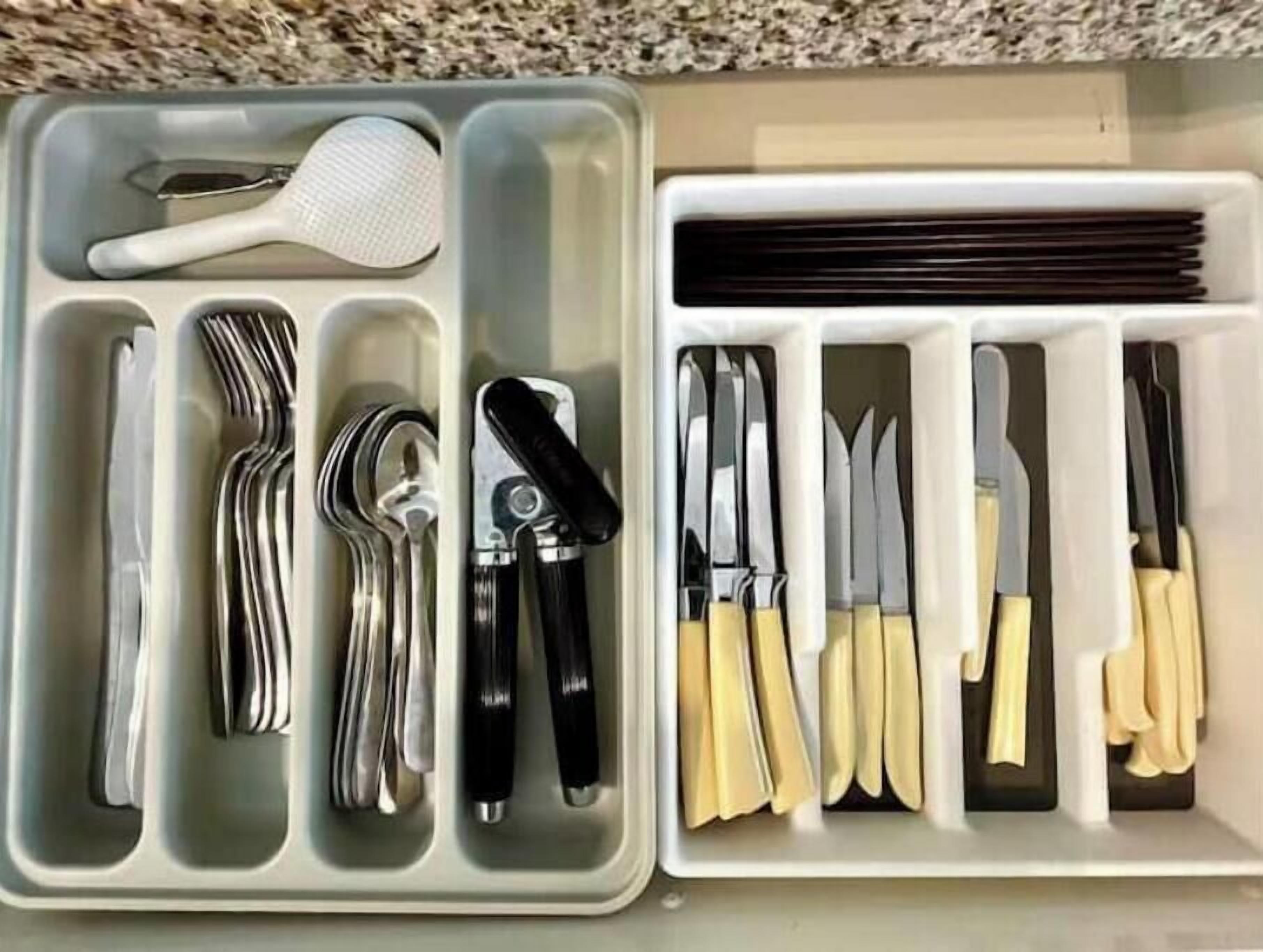A drawer with utensils and cutlery organized in compartments.