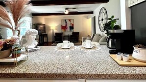 Una cocina con encimera de granito, una cafetera y un cartel que dice 