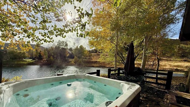 Un bain à remous avec vue sur un lac et des arbres.