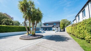 A modern two-story building with a flat roof and large windows. - Sea Haze (Tenby)