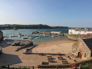 A coastal town with a marina, sandy beach, and stone buildings. - Sea Haze (Tenby)