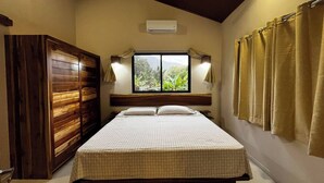 A bedroom with a bed, a window with curtains, a wooden wardrobe, and a ceiling fan. - Cool Comfort & Local Charm (Savegre de Aguirre)