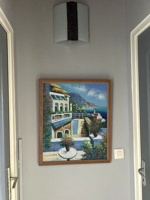 A painting of a coastal town with buildings and a sea view, framed and hung on a wall. - Villa panoramic sea view & private pool (Le Robert)
