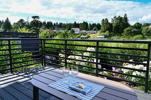 En træterrasse med et bord, to glas og en ostebakke.