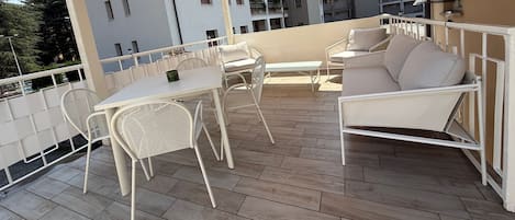 A terrace with outdoor furniture, a table, and a sofa.