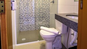 A bathroom with a shower, toilet, and sink. - MLG HOTEL (Mogi das Cruzes)